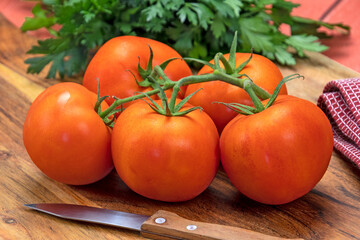 grappe de tomates rouges sur une planche à découper