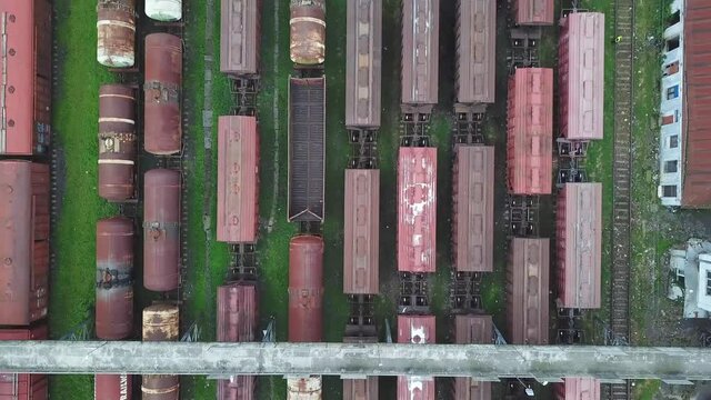 A drone flies over a railway station. A bird's-eye view from above. marshalling yard. there are a lot of railway cars. depot. Trains . Logistics and cargo transportation, containers and tanks.