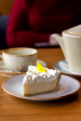 slice of mascarpone cheesecake with a cup of tea on the table in a cafe close-up