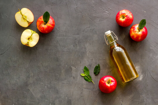 Bottle of organic apple cider vinegar with red apples