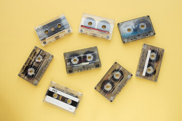 Old retro transparents audios cassettes on yellow background.