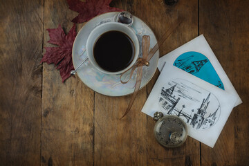 Cup of coffee, pictures and antique clock on wooden background. Directly above and copy space 