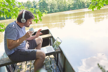 Freelancer in summer at the lake during video conference
