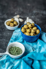olives in a blue bowl on a dark table