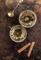 two china cups filled with tea leaves in hot water