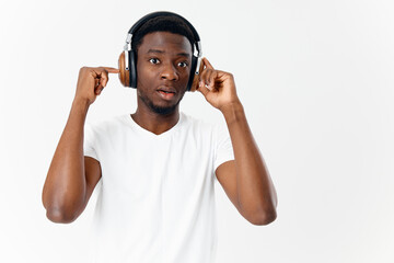 man of african appearance in white t-shirt with headphones listening to music