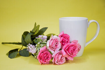 Obraz na płótnie Canvas White cup of tea with pink roses