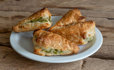 Pies filo pastry with chicken and spinach close-up on the wood deck. Selective focus.