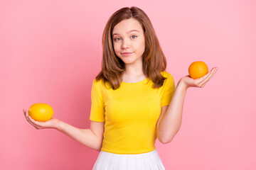 Photo of young girl happy positive smile hold hands orange fruit food weighing isolated over pink color background