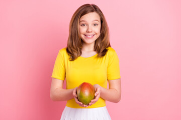 Photo of young cheerful girl happy positive smile hold mango exotic fruit summer isolated over pink...