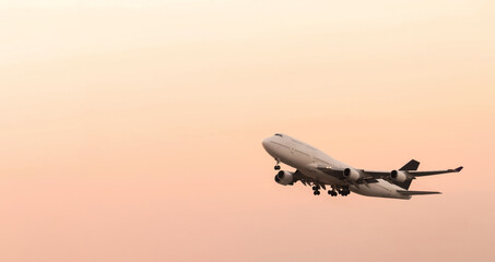 airplane taking off on airport runway at sunrise or sunset sky background. international global air logistics and transportation concept.