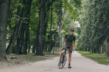 Positive man in activewear taking break after cycling