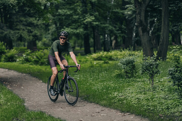 Fototapeta na wymiar Strong man having morning ride on bike at city park