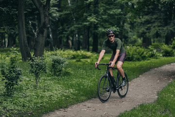 Fototapeta na wymiar Cyclist in helmet and glasses riding bike outdoors