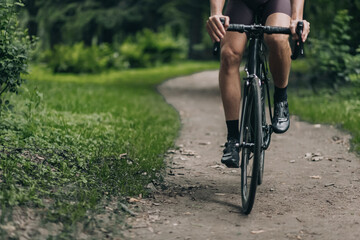 Close up of cyclist with strong legs riding at green park