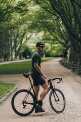 Fototapeta na wymiar Male cyclist taking break at park during workout