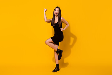 Fototapeta na wymiar Full size photo of hooray brunette hairdo young lady hands fists wear black dress shoes isolated on vivid yellow color background