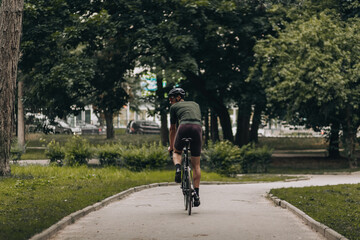 Fototapeta premium Caucasian male athlete in sport clothes biking on fresh air