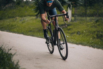 Fototapeta na wymiar Active male athlete using bike for training on fresh air