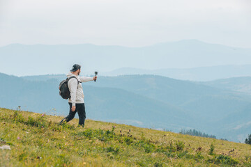 Naklejka na ściany i meble man with backpack hiking in mountains