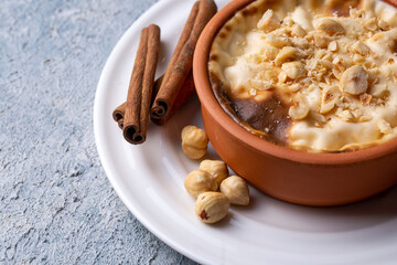 Baked rice pudding turkish milky dessert sutlac in earthenware casserole with hazelnuts