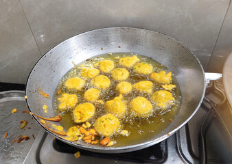 FRYING INDIAN SUBCONTINENT FOOD NAMED PAKORA, ALOO BHAJIYA, gram flour fritter