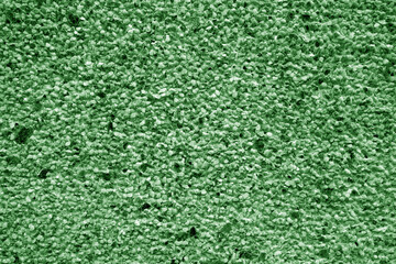 Wall covered with small stones in green tone.