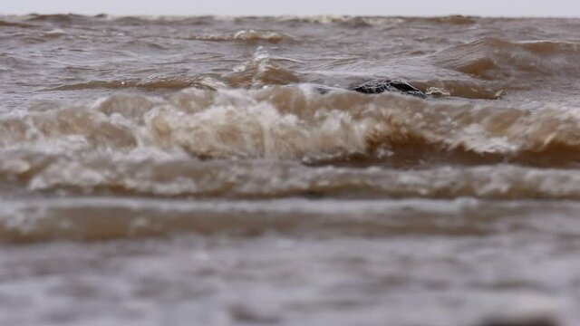 Waves crash on stone. Windy autumn weather on the shore of Lake Ilmen.
