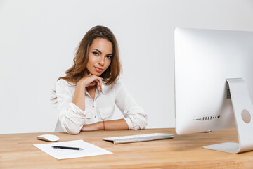 Ginger woman working with computer while sitting at desk