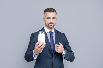 confident businessman man in businesslike suit presenting medical product of pill jar, healthcare business
