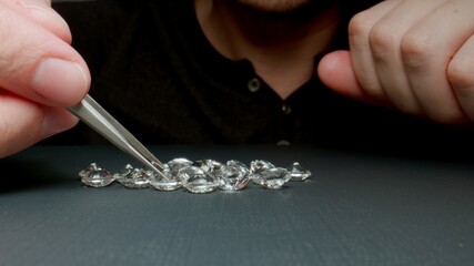 Jeweler examine diamonds on the table - 458520562