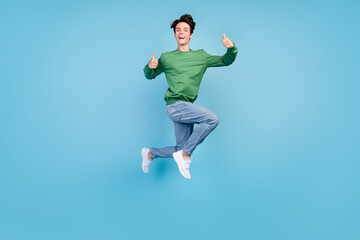 Fototapeta na wymiar Full length body size photo guy jumping up showing thumb-up isolated pastel blue color background