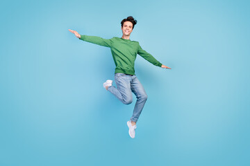 Fototapeta na wymiar Full length body size photo guy jumping high careless playful smiling isolated pastel blue color background