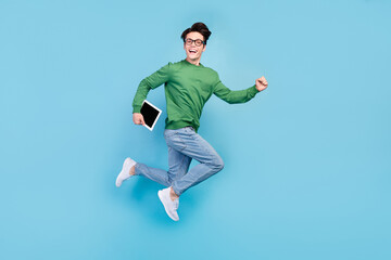 Fototapeta premium Full length body size photo guy jumping keeping tablet running on meeting isolated pastel blue color background