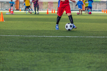 Children playing control soccer ball tactics cone on grass field with for training background Training