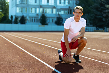 Obraz premium One young sportive man, male athlete, runner practicing alone before race at public stadium, sport court or running track, outdoors. Professional sport games.