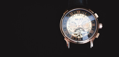 Wristwatch close-up on a dark background.