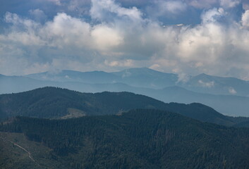 Obraz premium mountain slopes in the Ukrainian Carpathians. mountain tops and forests on a background of blue sky