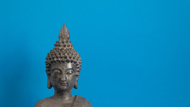 figure gray buddha on blue background