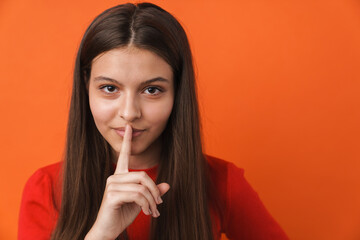 Naklejka premium Young white brunette woman showing silence gesture at camera