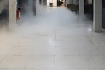 Dissipating cloud of nitrogen gas floating low inside building corridor