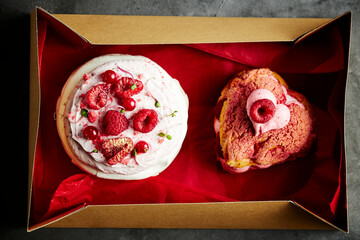 Two French valentine cream cakes in a gift box with red background