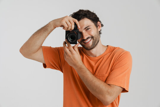 Young brunette man with bristle smiling while taking photo