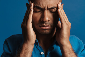 Black bold man with headache rubbing his temples