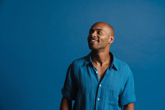 Black Bold Man Wearing Shirt Smiling And Looking Aside