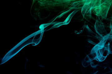 Obraz premium Abstract colored smoke moves on dark background. Wallpaper. Personal vaporizers fragrant steam. Concept of alternative non-nicotine smoking. E-cigarette. Texture. Design elements.