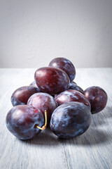 Fresh plums. Fruits. On a white wooden background. Copy space.