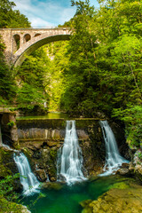 Vintgar Gorge in Slovenia. Stone Arch Rail Bridge over Waterfall