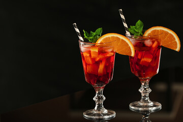 Delicious sangria cocktail on black table in bar. Space for text