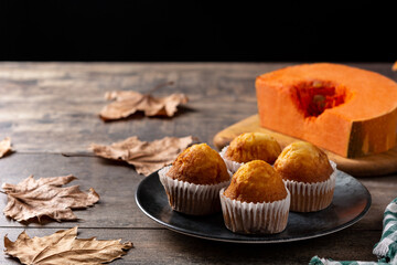 Pumpkin muffins on rustic wooden table. Autumn dessert